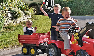 Kinder von der Familie Rettensteiner auf dem Kindertraktor